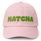 Pink cap with 'MATCHA' in green text on a white background